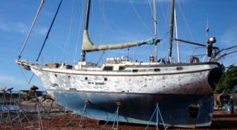 photo d'un voilier au sec, représentant une coque en ferrociment, blanc et bleu, avec sa longue quille lui permettant une bonne tenue de route en mer, photo du site Banik