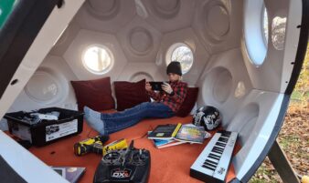 chambre ado conker living blanc, jeune jouant à sa console vidéo, ses jouets éparpillés au sol