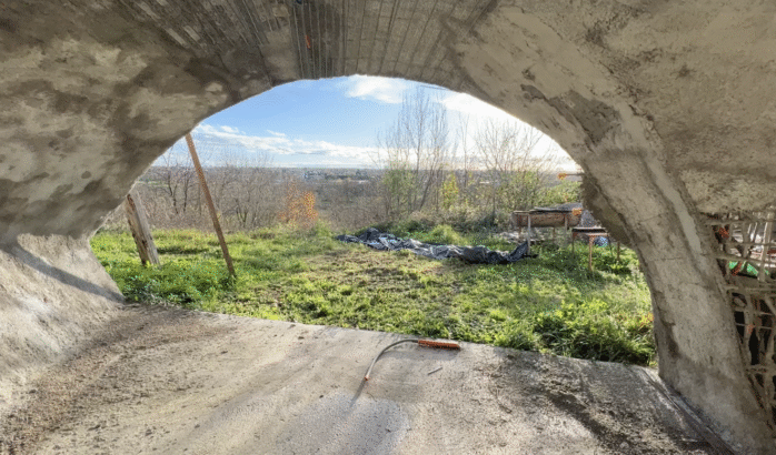 photo de la grande baie demi lune du studio de la maison bulle de Montgivray depuis l'intérieur avec une superbe vue sur le paysage de La Châtre