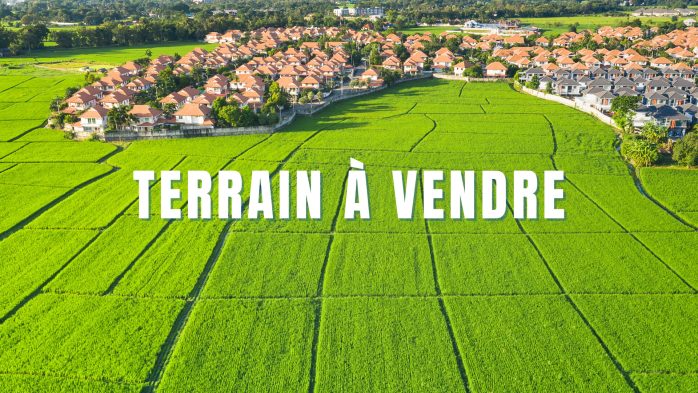 image présentant une vue aérienne d'un village avec des terrains devant et le texte "terrain à vendre"