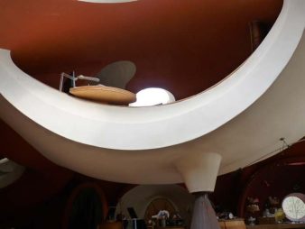 Bureau aménagé dans un hamac suspendu intégré à une maison bulle en béton