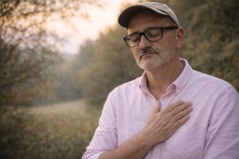Homme en introspection main sur le cœur après un 3ème AVC – message de prévention sur le stress