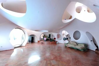 Hamac architectural en béton massif suspendu dans une maison bulle aux formes organiques