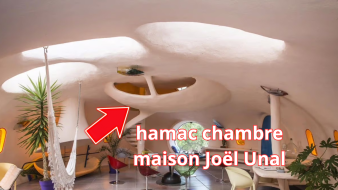 Intérieur d’une maison bulle en béton blanc avec volume suspendu organique et formes courbes continues sans joints apparents