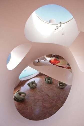 Hamac suspendu dans une maison bulle permettant de rester relié à la pièce du bas tout en étant en retrait