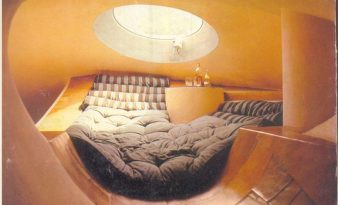 Hamac en béton sous un puits de lumière zénithal dans une maison bulle aux formes organiques