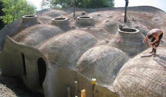 Construction d’une maison organique avec coffrage béton et formes courbes montrant la complexité du chantier